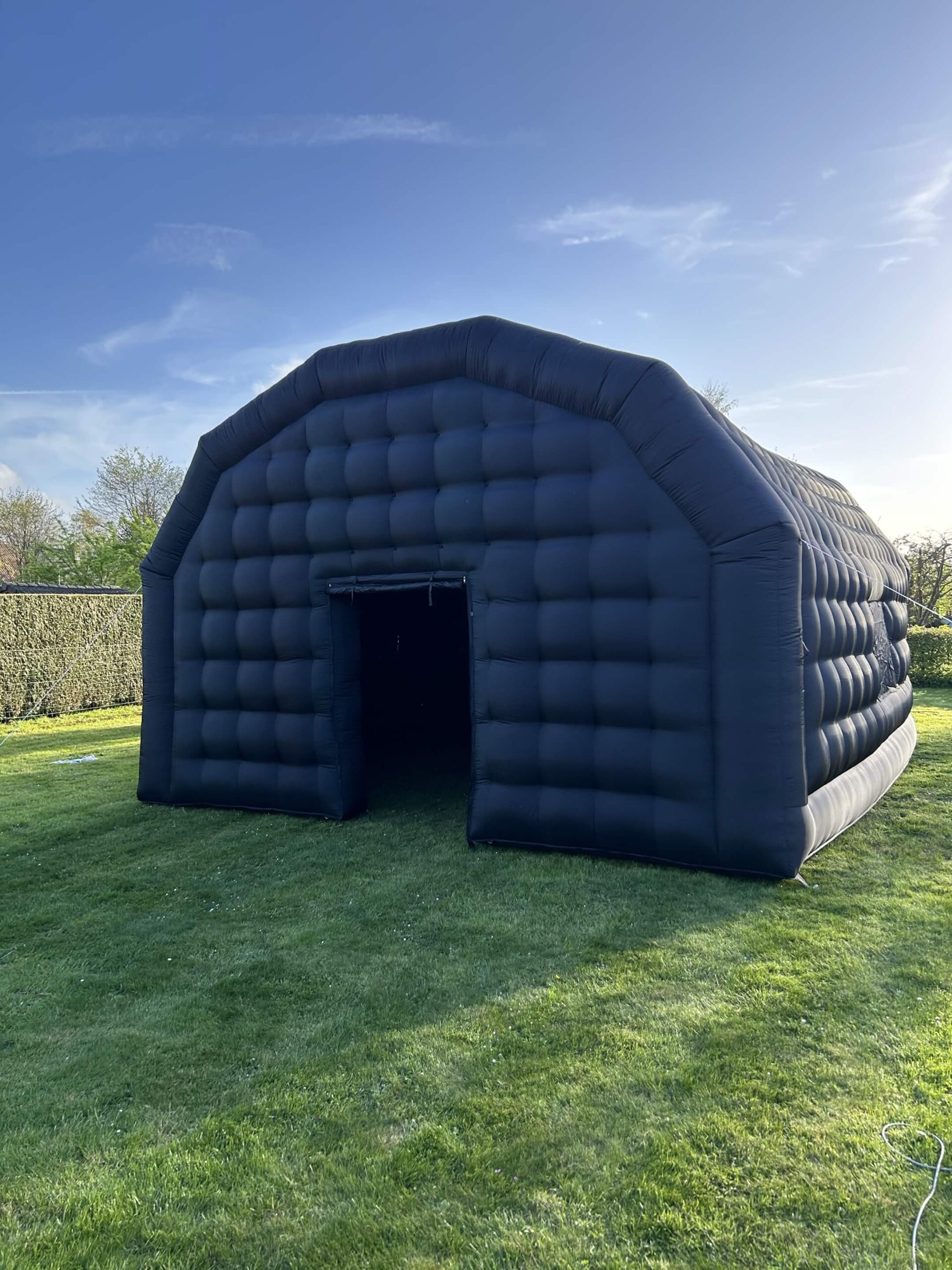 La véritable boîte de nuit gonflable noire JFR Event installée dans un jardin
